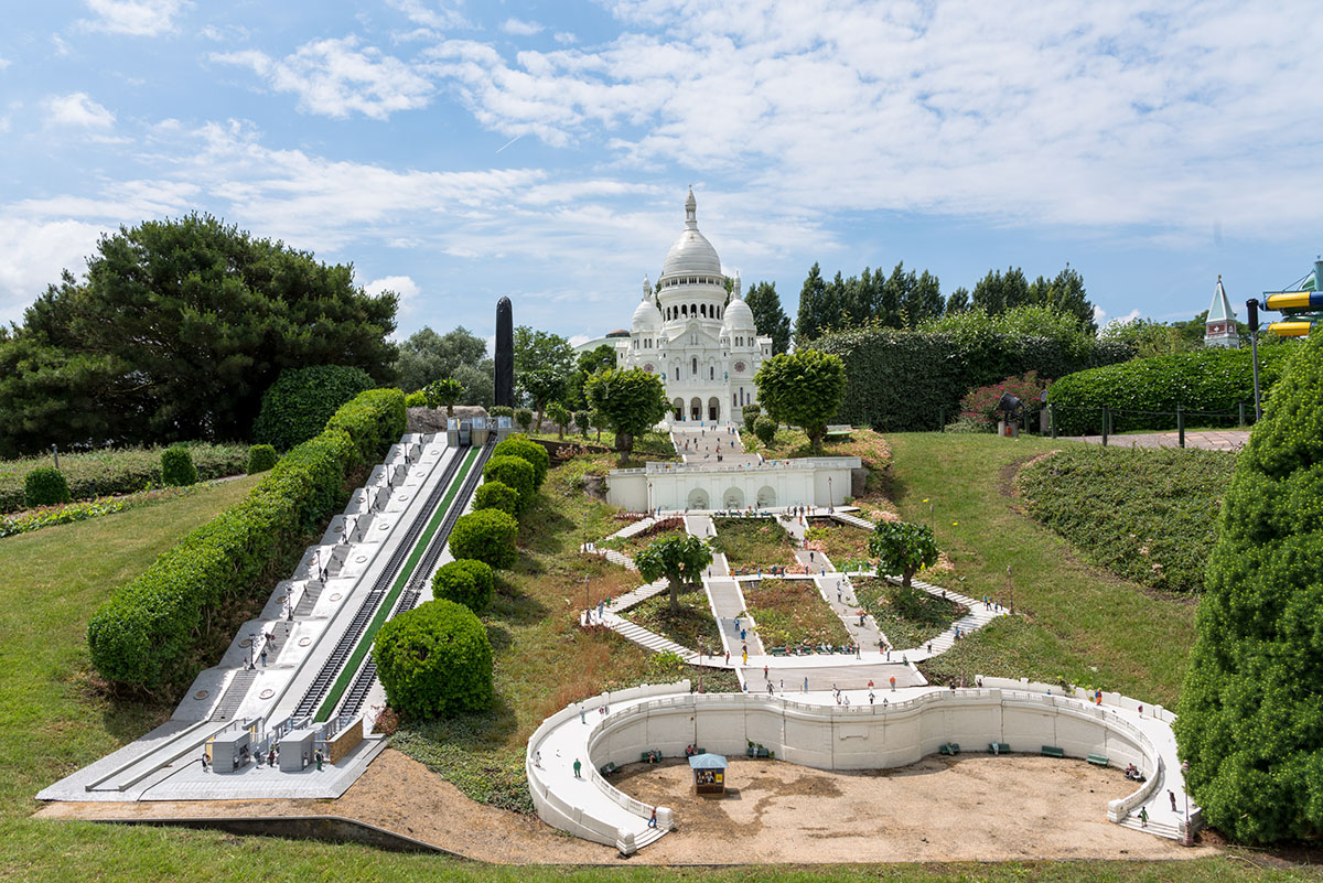 Miniature versions of famous buildings set into a green park and hill with a lift going to the top